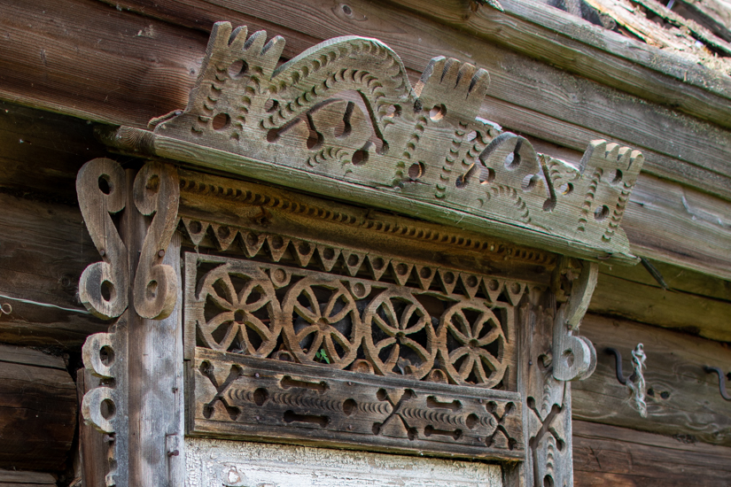 Старинный резной наличник окна деревенского дома (фрагмент)